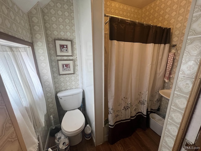 bathroom featuring hardwood / wood-style flooring, toilet, and a shower with shower curtain