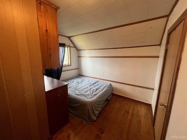 bedroom with lofted ceiling and dark hardwood / wood-style floors