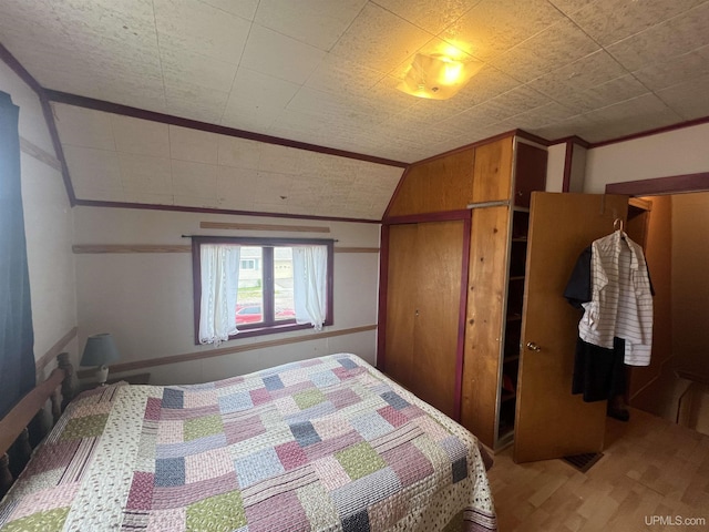 bedroom with vaulted ceiling, wood walls, and wood-type flooring