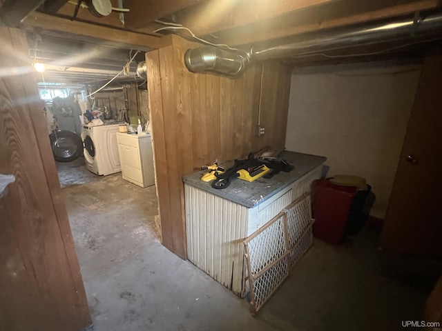 basement featuring washer and dryer and wood walls