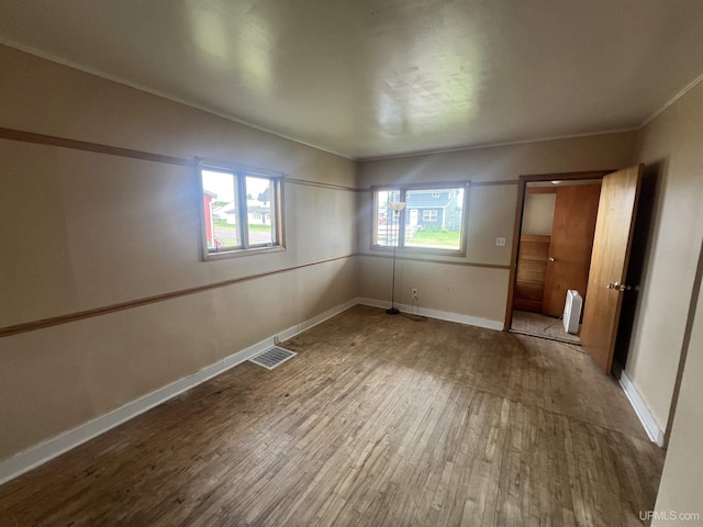 unfurnished bedroom with hardwood / wood-style flooring and crown molding