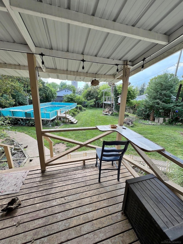 wooden deck with a pool and a yard