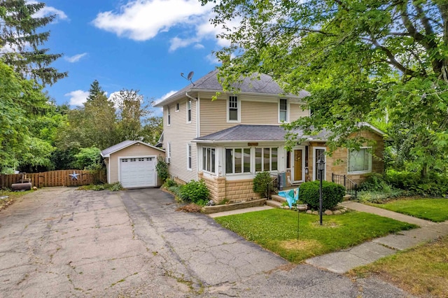 view of property featuring a garage, an outbuilding, and a front yard