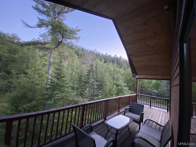 wooden deck with a forest view