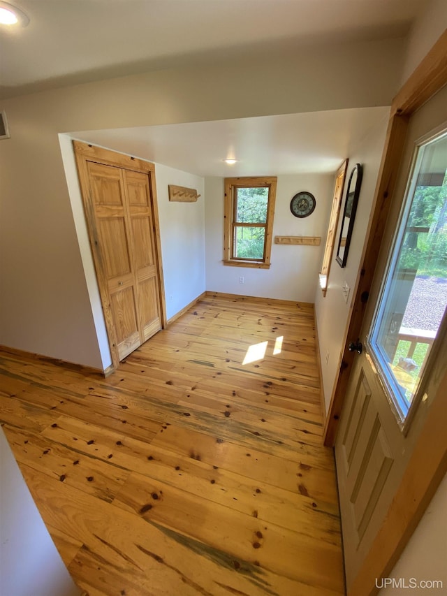 interior space featuring baseboards, visible vents, and light wood-style floors