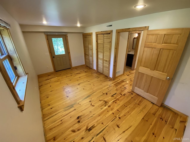 foyer featuring light wood-style floors and visible vents