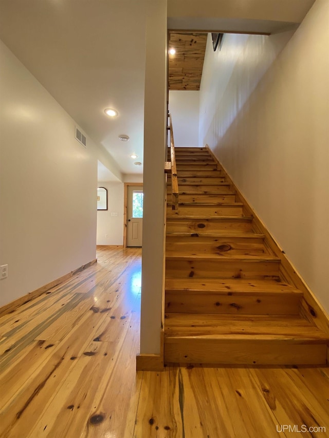 stairway with hardwood / wood-style flooring, visible vents, and recessed lighting