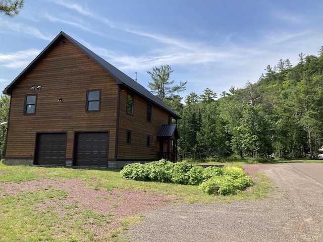 view of side of home featuring driveway and an attached garage