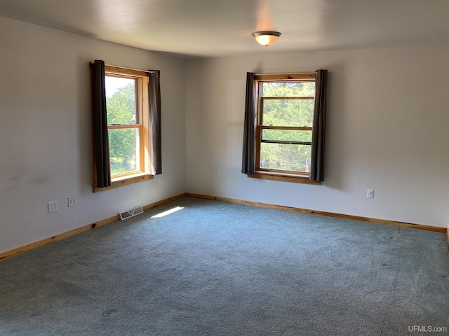 carpeted empty room featuring visible vents and baseboards