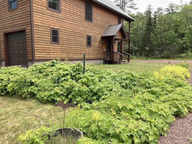 view of property exterior featuring metal roof and an attached garage