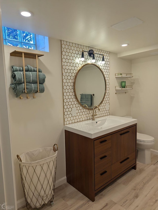 bathroom with hardwood / wood-style floors, vanity, and toilet