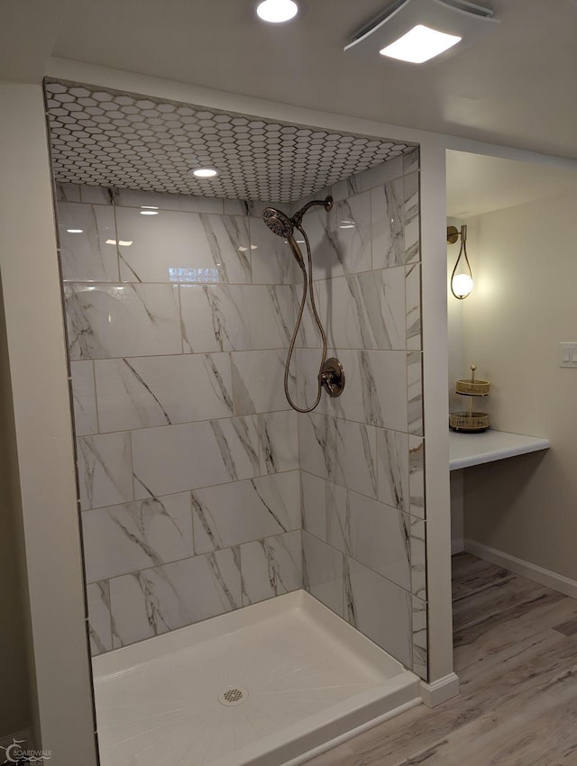 bathroom featuring a tile shower and hardwood / wood-style floors