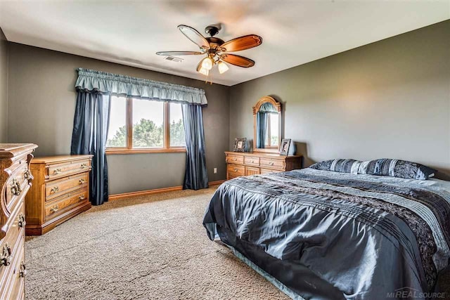 bedroom featuring baseboards, a ceiling fan, visible vents, and light colored carpet