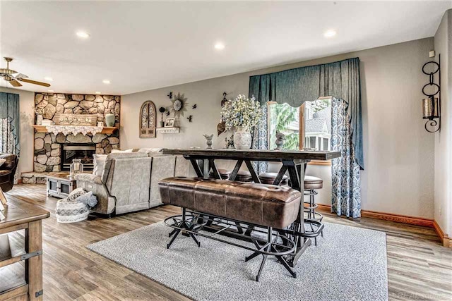 interior space with ceiling fan, a fireplace, and hardwood / wood-style flooring