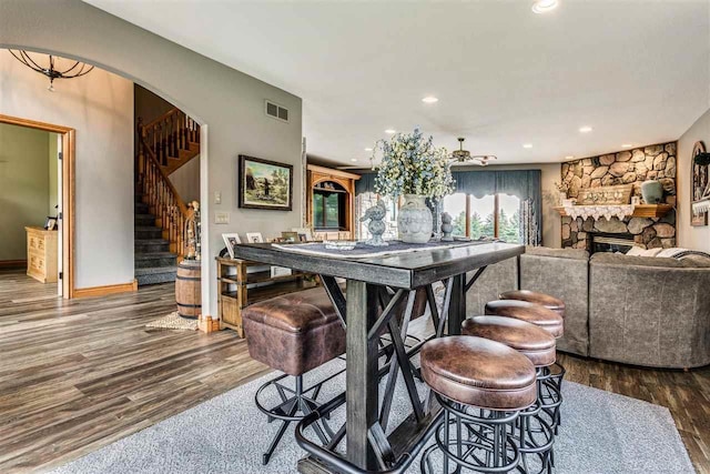 dining space with a stone fireplace and hardwood / wood-style flooring