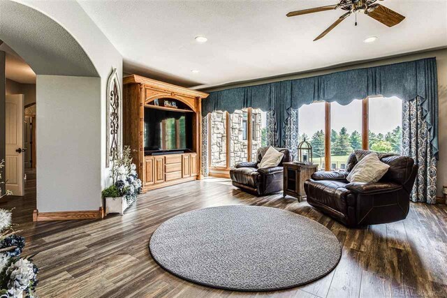 living room featuring ceiling fan, a textured ceiling, and hardwood / wood-style flooring