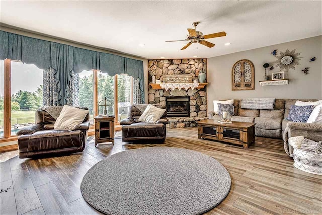 living room featuring hardwood / wood-style flooring, a fireplace, and ceiling fan