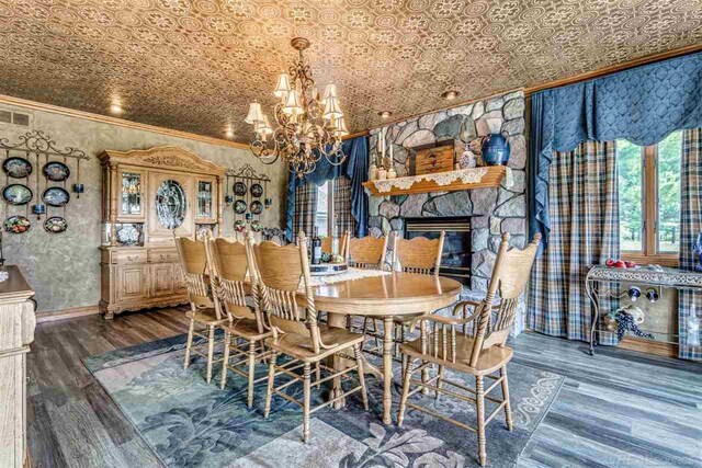 dining space featuring a notable chandelier, dark hardwood / wood-style flooring, and ornamental molding