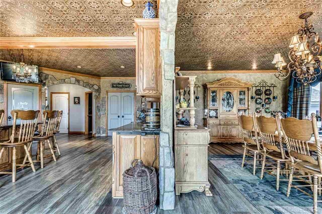 kitchen with crown molding, pendant lighting, dark hardwood / wood-style flooring, and a notable chandelier