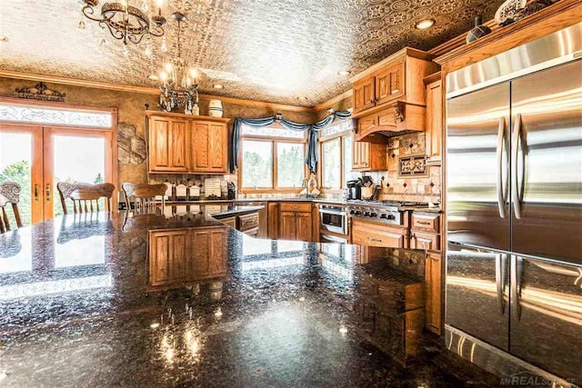 kitchen featuring hanging light fixtures, an ornate ceiling, ornamental molding, and stainless steel appliances