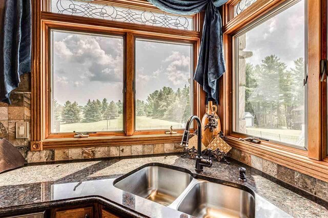 kitchen featuring dark stone counters and sink