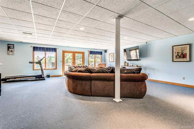 carpeted living room with decorative columns and a paneled ceiling