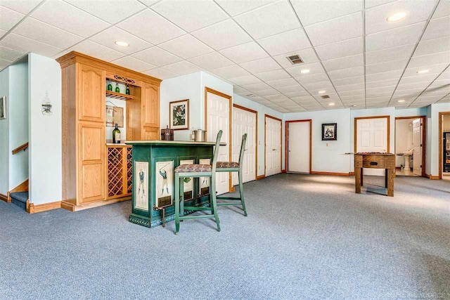 bar featuring a paneled ceiling and carpet flooring