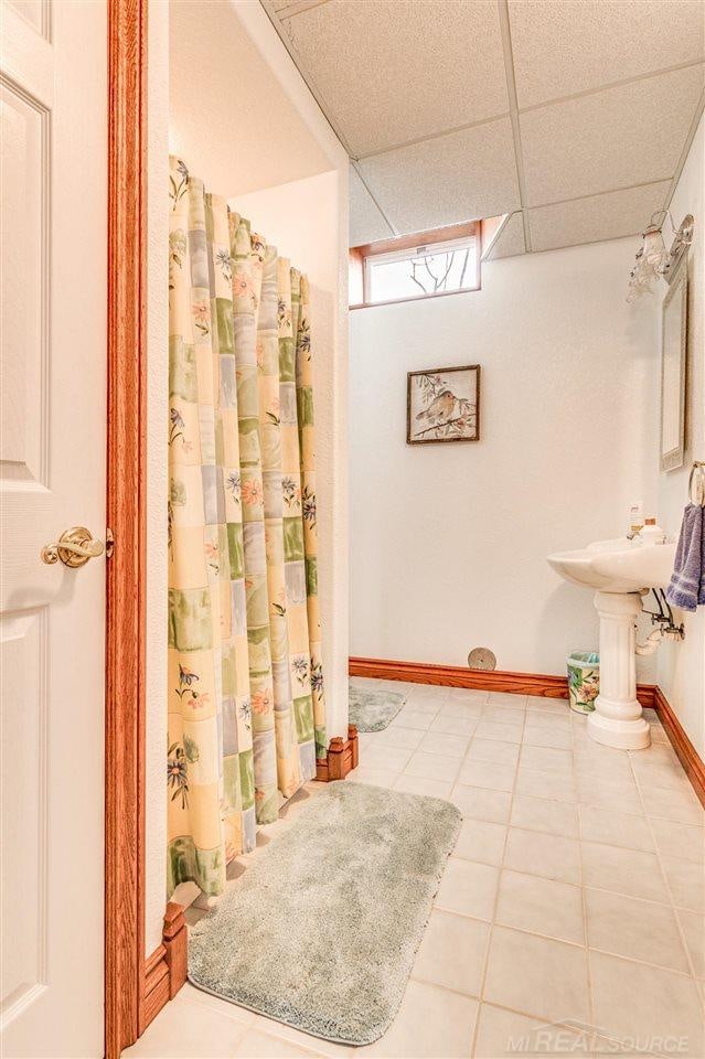 bathroom featuring a drop ceiling and tile patterned floors