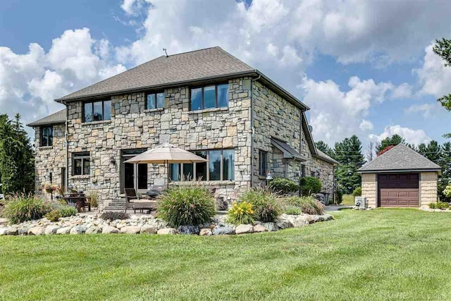 rear view of house with a garage, a yard, stone siding, and central air condition unit