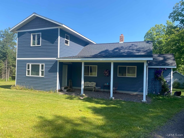 back of house featuring a porch and a lawn