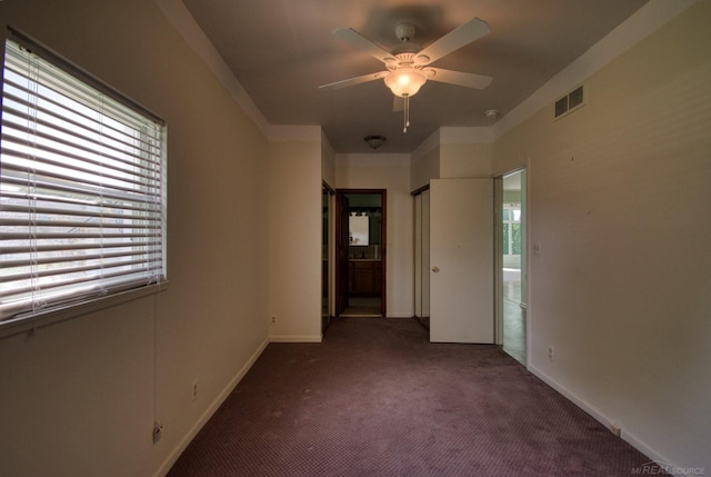 empty room with dark carpet and ceiling fan