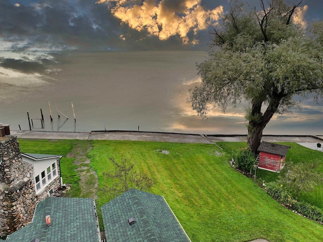 yard at dusk featuring a water view