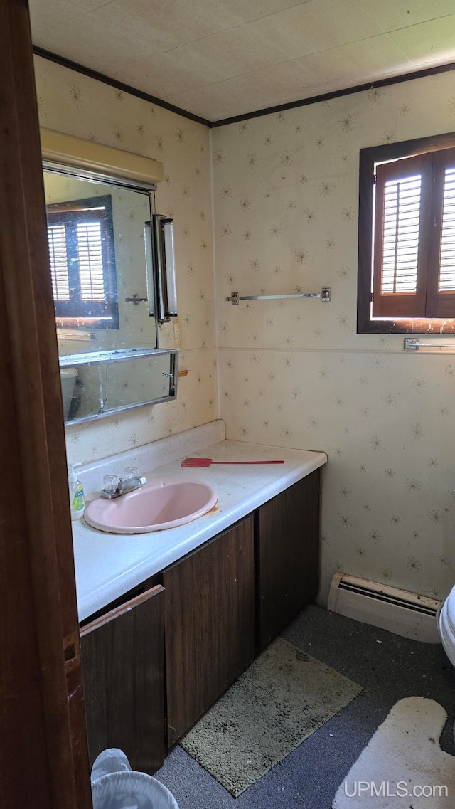 bathroom featuring vanity, a healthy amount of sunlight, and a baseboard heating unit