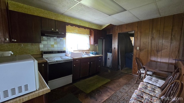 kitchen with a paneled ceiling, white electric stove, wooden walls, dark brown cabinets, and hardwood / wood-style flooring