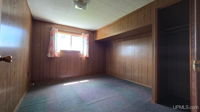 carpeted empty room with wood walls