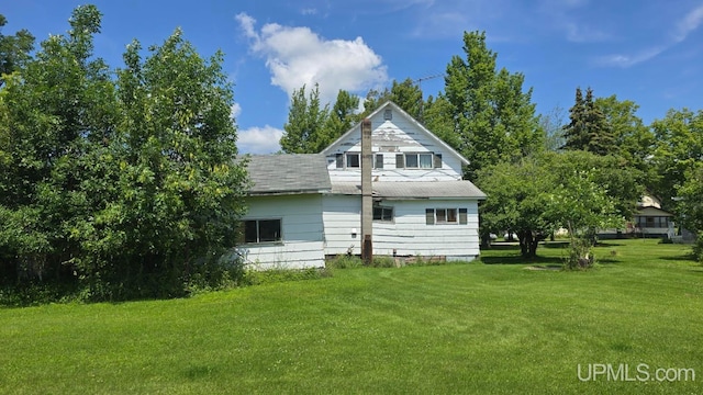 back of property featuring a yard