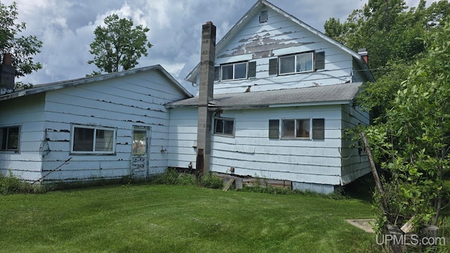 back of house featuring a lawn