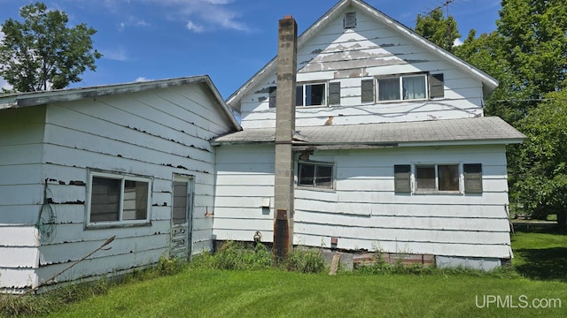 rear view of house featuring a yard