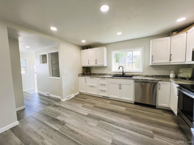 kitchen featuring light hardwood / wood-style floors, sink, stainless steel appliances, and white cabinetry