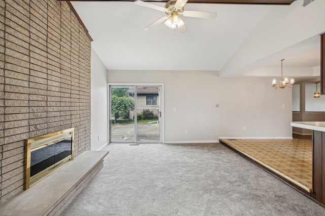 unfurnished living room with ceiling fan with notable chandelier, carpet floors, vaulted ceiling, and a brick fireplace