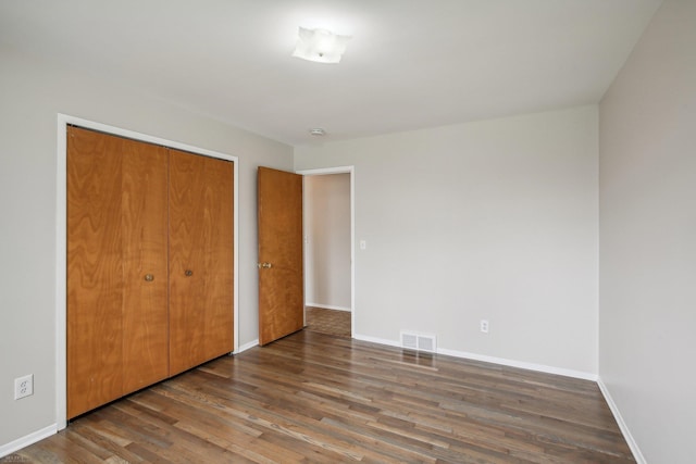 unfurnished bedroom with hardwood / wood-style flooring and a closet