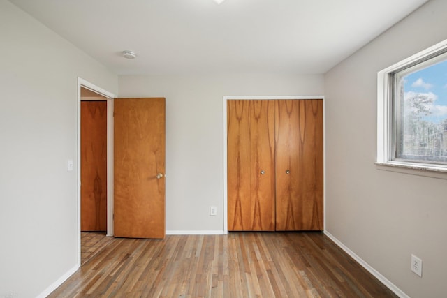 unfurnished bedroom with light hardwood / wood-style floors and a closet