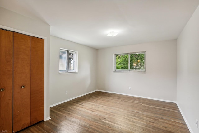 unfurnished bedroom featuring dark hardwood / wood-style flooring and a closet