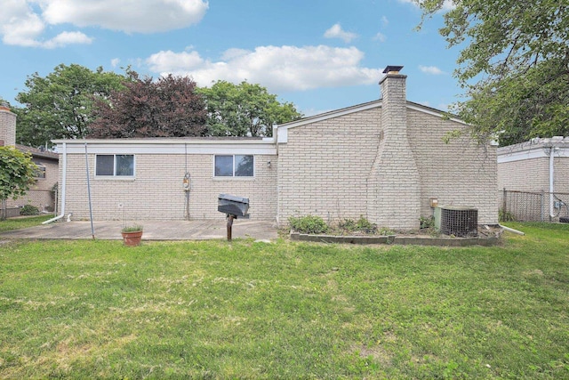 rear view of house featuring central AC unit, a patio area, and a yard