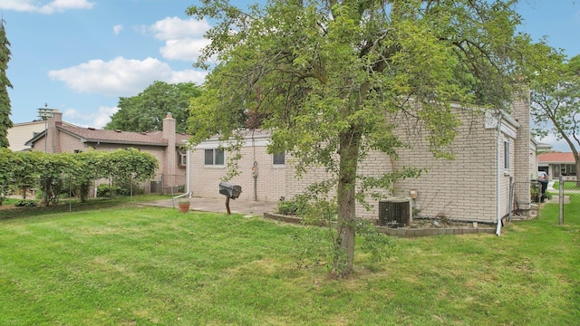 exterior space with a yard and central AC