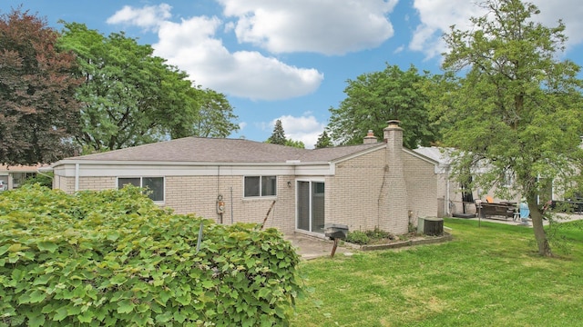 back of property featuring a yard and central air condition unit