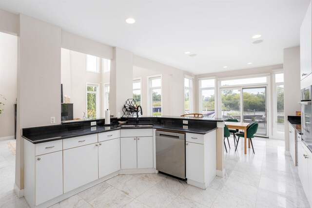 kitchen featuring appliances with stainless steel finishes, white cabinetry, light tile patterned floors, and sink