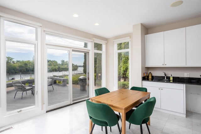 dining space featuring sink and light tile patterned floors