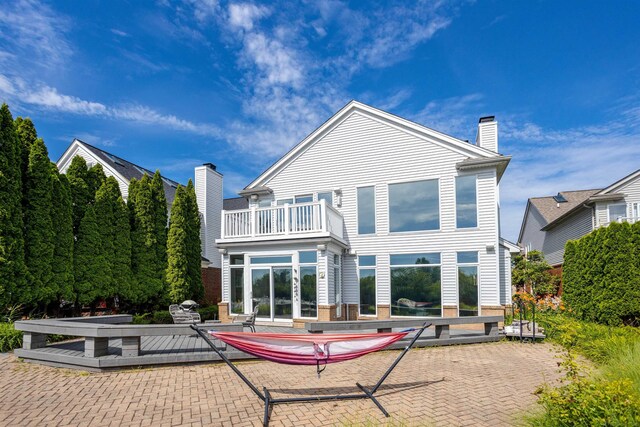 rear view of house featuring a balcony and a patio