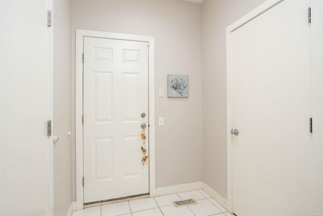 entryway with light tile patterned flooring and baseboards